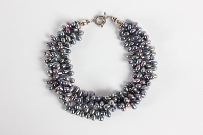 Lot 40 - A triple strand grey pearl necklace, 1980s,...