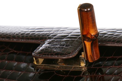 Lot 10 - A Gucci brown crocodile clutch bag with bamboo lift-clasp, early 1970s
