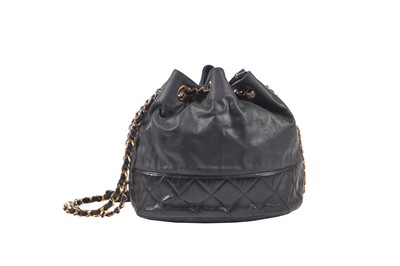Lot 14 - A Chanel waxed canvas and navy quilted leather bucket bag, 1986-1988