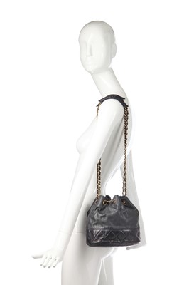 Lot 14 - A Chanel waxed canvas and navy quilted leather bucket bag, 1986-1988