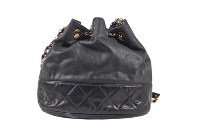 Lot 14 - A Chanel waxed canvas and navy quilted leather bucket bag, 1986-1988