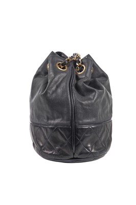 Lot 14 - A Chanel waxed canvas and navy quilted leather bucket bag, 1986-1988