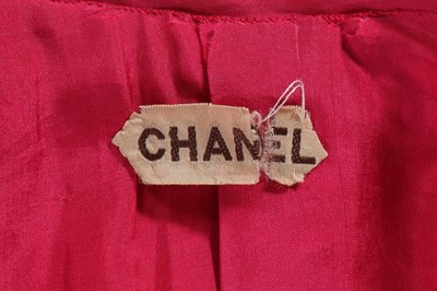 Lot 35 - A Chanel couture raspberry-pink tweed suit, circa 1960