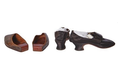 Lot 423 - A pair of black satin shoes and a pair of unusual brown leather pattens, 1770-1780