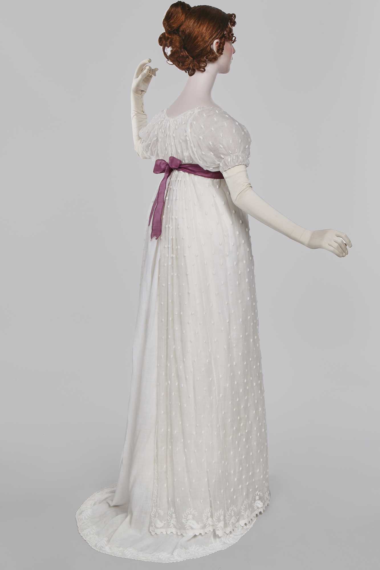 Lot 36 - A rare embroidered white spotted muslin tablier dress, French, circa 1802