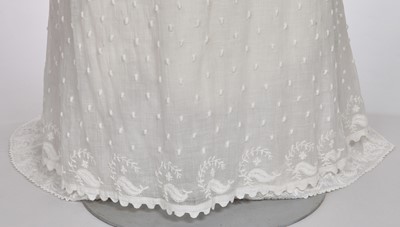 Lot 36 - A rare embroidered white spotted muslin tablier dress, French, circa 1802