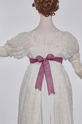 Lot 36 - A rare embroidered white spotted muslin tablier dress, French, circa 1802