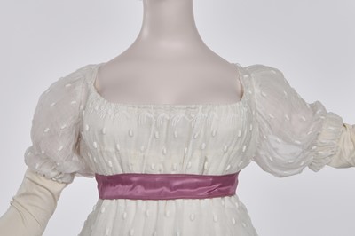 Lot 36 - A rare embroidered white spotted muslin tablier dress, French, circa 1802