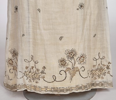 Lot 10 - A fine embroidered and spangled white linen evening gown, French, circa 1796