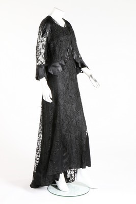 Lot 70 - A Worth-labelled black lace and ciré satin...