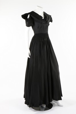Lot 50 - A Norman Hartnell couture black satin dress,...