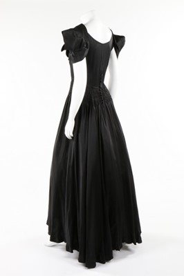 Lot 50 - A Norman Hartnell couture black satin dress,...