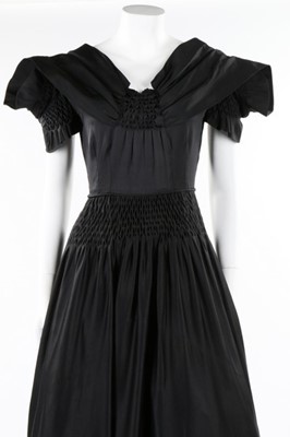 Lot 50 - A Norman Hartnell couture black satin dress,...
