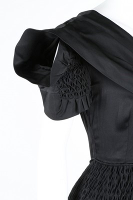 Lot 50 - A Norman Hartnell couture black satin dress,...