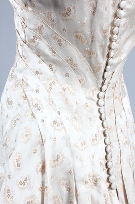 Lot 143 - A gold and ivory brocaded satin bridal gown,...
