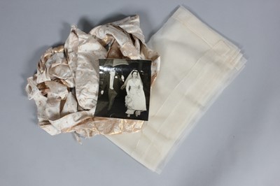 Lot 143 - A gold and ivory brocaded satin bridal gown,...