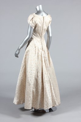 Lot 143 - A gold and ivory brocaded satin bridal gown,...