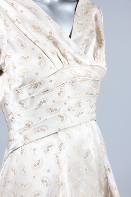 Lot 143 - A gold and ivory brocaded satin bridal gown,...