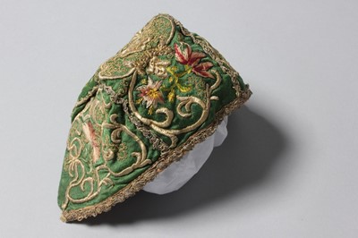 Lot 150 - An embroidered green satin baby cap, probably...
